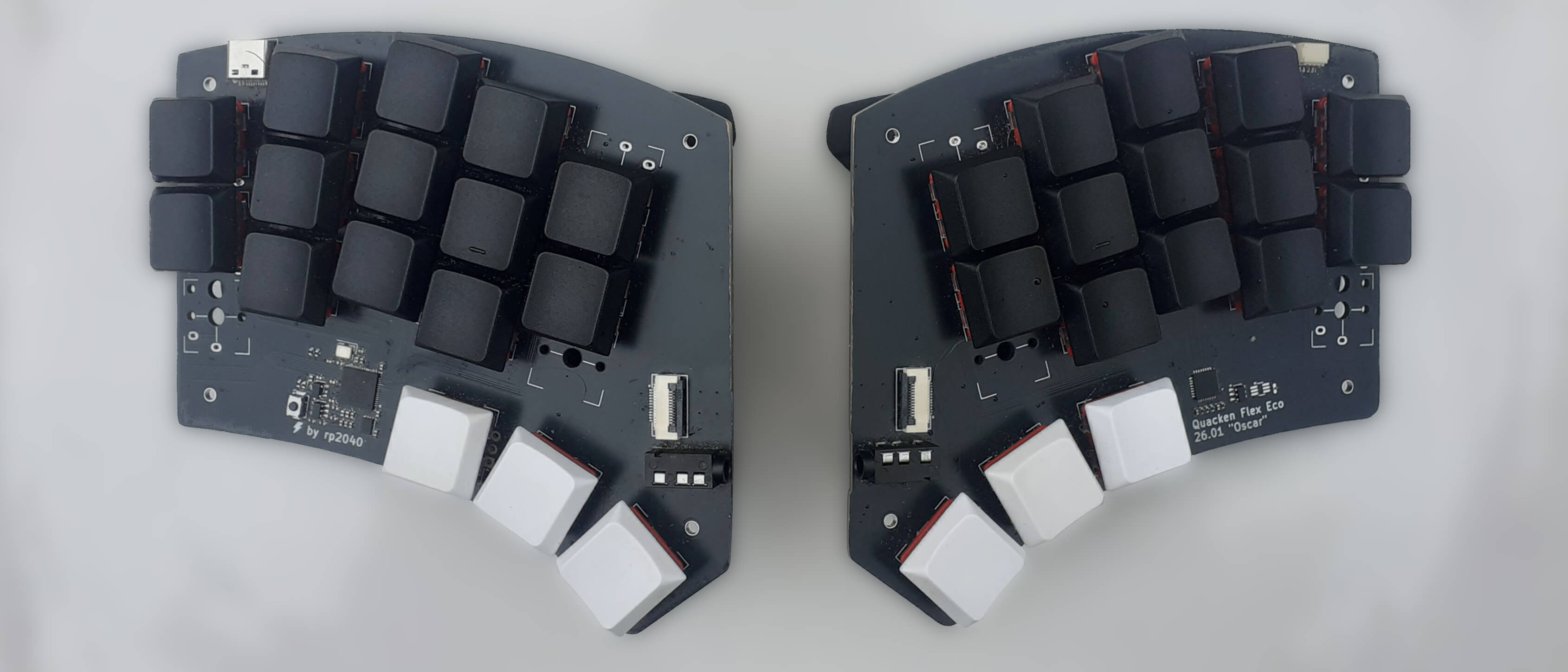 a split Quacken keyboard seen from above: 30 keys, white keycaps on thumb keys, black keycaps on all other keys